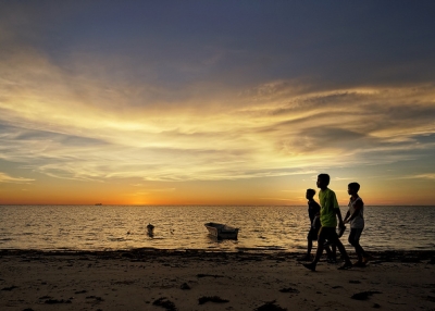 Three boys stroll along the beach at Labuan, Malaysia on April 16, 2013. (SaturatedEyes/Flickr)