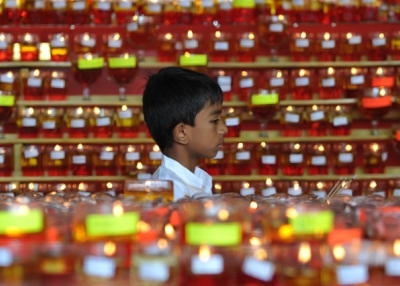 A young Buddhist devotee walks past rows of candles for Vesak Day celebrations at a Buddhist temple in Kuala Lumpur, Malaysia on May 24, 2013. (Mohd Rafsan/AFP/Getty Images)