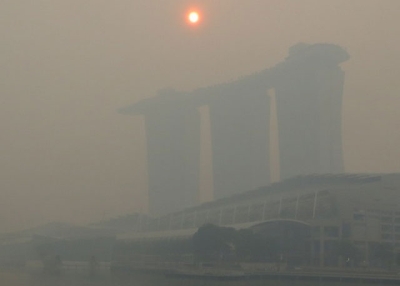The mid-morning sun struggles to shine through a thick smoke haze above the three towers of the Marina Bay Sands casino resort on Singapore, Friday June 21, 2013. (Geoff Spencer)