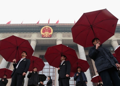 Soldiers dressed as ushers hold umbrellas at the Great Hall of the People