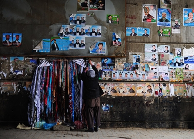 An Afghan roadside vendor hangs scarves next to political leaflets on a wall in Kabul on April 4, 2014. Some 12 million Afghans will go to the polls on April 5 to elect a new president. (Roberto Schmidt/AFP/Getty Images)