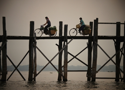 Two people cycle their way across the U Pain Bridge, built over 2000 years ago, in Mandalay, Myanmar on October 10, 2014. (Rajesh_India/Flickr)