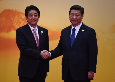 Japan's Prime Minister Shinzo Abe (L) shakes hands with China's President Xi Jinping as he arrives for the Asia-Pacific Economic Cooperation (APEC) leaders meeting at Yanqi Lake, north of Beijing on November 11, 2014. (Greg Baker/Getty Images)