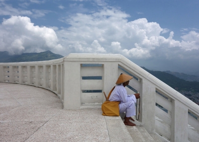 A man counts prayer beads at the top of World Peace Monument Pokhara in Nepal on July 8, 2014. (drburtoni/Flickr)