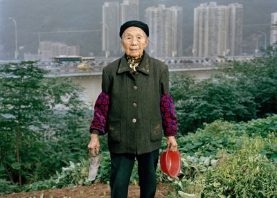 Zhong Baixin, eighty-seven, is cultivating a square meter of lettuce for her own table. She has lived all her life in Chongqing and now lives in what remains of a farming village stuck between a construction site and a road. (Tim Franco)