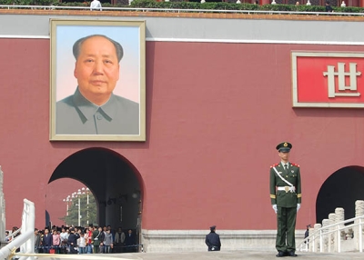 A soldier stands guard in front of Mao Zedong's portrait at Tiananmen Square in Beijing. (Matt Spurr/Flickr)