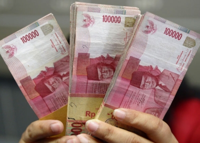 An Indonesian clerk holds stacks of Indonesian rupiah notes at a currency exchange office in Jakarta on Sept. 4, 2013. (Adek Berry/AFP/Getty Images) 