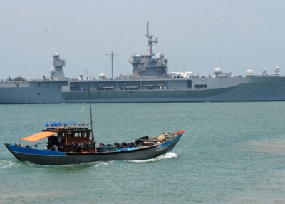 A Vietnamese fishing boat sails next to the U.S. 7th Fleet's flagship USS Blue Ridge entering Tien Sa port on April 23, 2012. (Hoang Dinh Nam/AFP/Getty Images) 