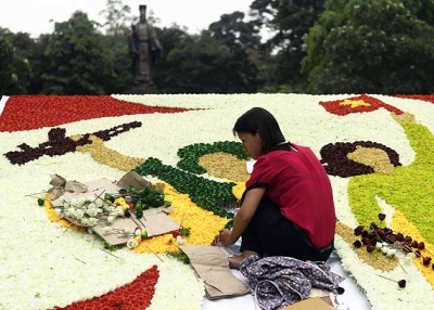 A worker uses plastic flowers to build a display marking the 38th anniversary of the end of the Vietnam War at a public park in the centre of Hanoi on April 24, 2013. (Hoang Dinh Nam/AFP/Getty Images) 