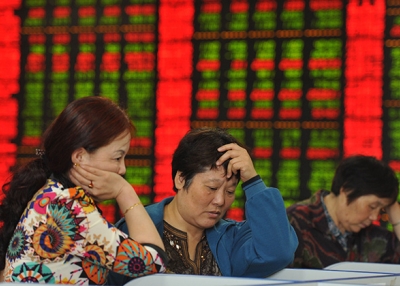 Investors check share prices in a stock firm in Fuyang, China on June 29, 2015. (STR/AFP/Getty Images)