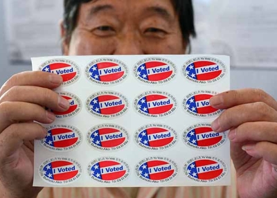 Election official Henry Tung displays a sheet of "I Voted" stickers at a polling station in Monterey Park, Los Angeles County. (Frederic J. Brown/AFP/Getty)