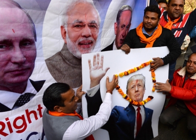 Right-wing activists of India's Hindu Sena party pose with a poster of Russian President Vladimir Putin, (L), Indian Prime Minister Narendra Modi (2L) and US President-elect Donald Trump (R) during an event in New Delhi on January 19, 2017.(Sajjad Hussain/AFP/Getty Images)