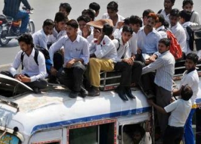 Pakistani students sit on top of an overloaded mini bus as they ride home from school in Lahore on Sept. 8, 2009