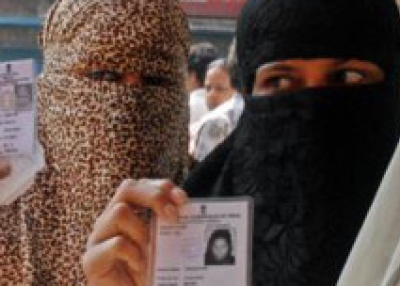 Muslim women flash their their voter ID cards before voting in the 14th Lok Sabha election in Kolkata, Jan. 2010. (Sushanta Patronobish/thehindu.com)