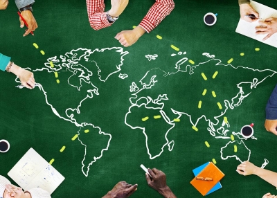People collaborate around a map of the world.
