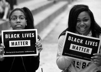 Two people hold Black Lives Matters signs at a protest (Tom Hilton/Flickr)
