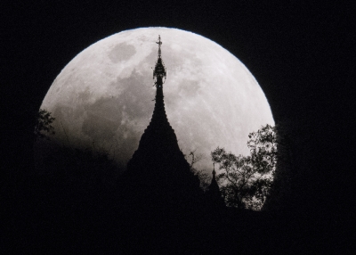 The moon rises over a pagoda in Kumal, Myanmar