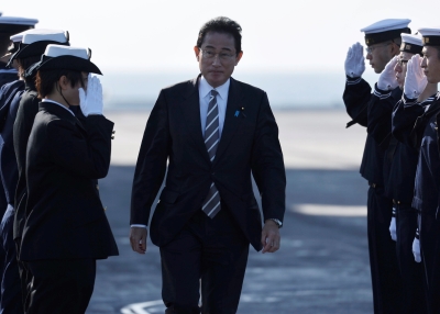 Japanese Prime Minister Fumio Kishida is saluted by members of the Japan Maritime Self-Defence Force
