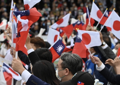 Lawmakers from Taiwan and Japan wave flags at a ceremony to mark the island's National Day in front of the Presidential Office in Taipei on October 10, 2022.