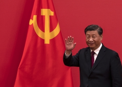 Xi Jinping in front of a red hammer-and-sickle flag
