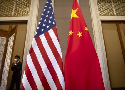 A staff member wearing a face mask walks past United States and Chinese flags set up before a meeting between Treasury Secretary Janet Yellen and Chinese Vice Premier He Lifeng at the Diaoyutai State Guesthouse on July 8, 2023 in Beijing, China. 