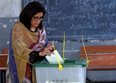 A female voter casts her ballot at a polling station during the by-election for national assembly seats, in Karachi on October 16, 2022. 