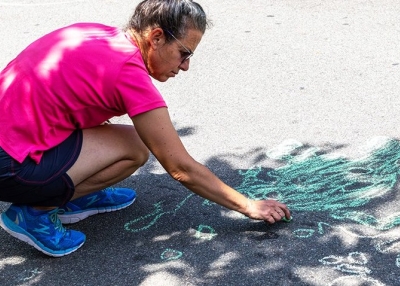 Person making chalk drawing on pavement