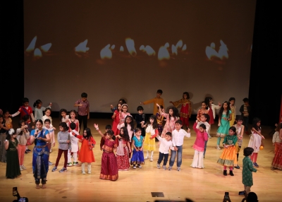 a picture of children dancing in the auditorium during asia society diwali family day 2023
