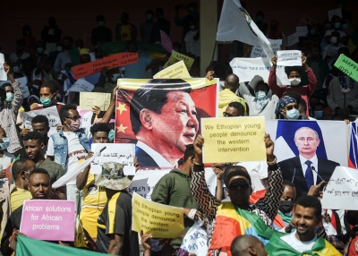 Protesters hold the portraits of China's President Xi Jinping (and Russia's President Vladimir Putin among their messages during a massive rally