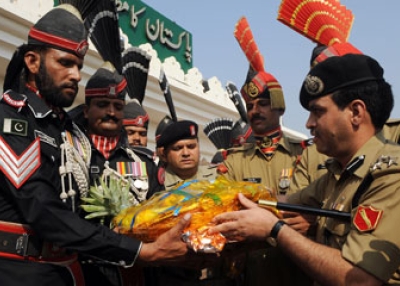 Indian Deputy Inspector General of Border Security Force (BSF) Mohammad Aquil (R) presents sweets to Pakistani Rangers personnel prior to a meeting on Oct.14, 2009.
