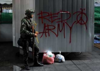 A Thai soldier stands next to graffitti inside the Red Shirt anti-government protesters camp in Bangkok on May 20, 2010. (Manan Vatsyayana/AFP/Getty Images)