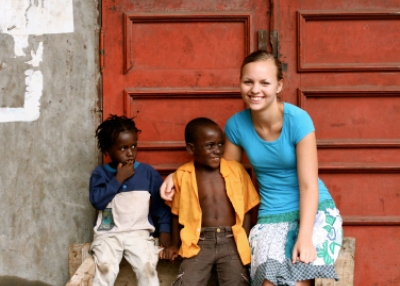 Student studying abroad, posing with children. (Miss Hibiscus / istockphoto)