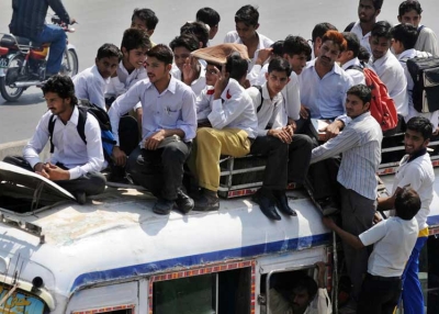 Pakistani students sit on top of an overloaded mini bus as they ride home from school in Lahore on September 8, 2009. (Arif Ali/AFP/Getty Images)