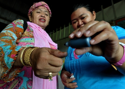 An election official drips indelible ink onto the fingers of Filipina voter after casting her ballot in a polling station in Maguindanao, May 10, 2010. (Jay Directo/AFP/Getty Images)