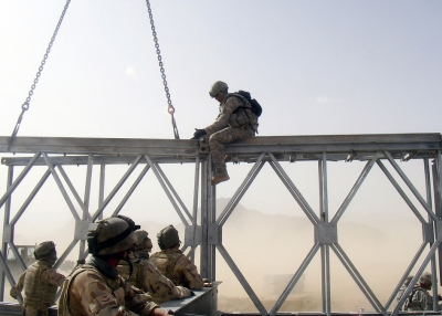 Spc. Corey Thompson, 420th Engineer Brigade, works with Australian combat engineers as they align two sections of a bridge. (Capt. James Reid/Flickr)