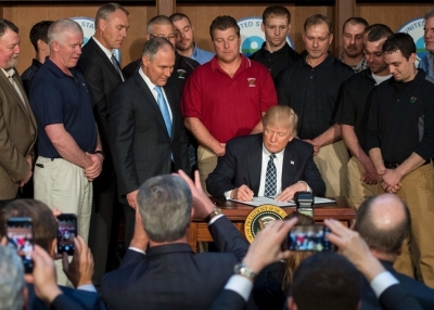 Surrounded by miners from Rosebud Mining, US President Donald Trump (C) signs the Energy Independence Executive Order at the Environmental Protection Agency (EPA) Headquarters in Washington, DC, March 28, 2017. (Jim Watson/AFP/Getty Images)