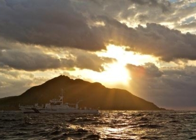 A Japanese Coast Guard boat passes by Uotsuri, the largest island in the Senkaku/Diaoyu chain, in October 2012. (Al Jazeera English/Flickr)