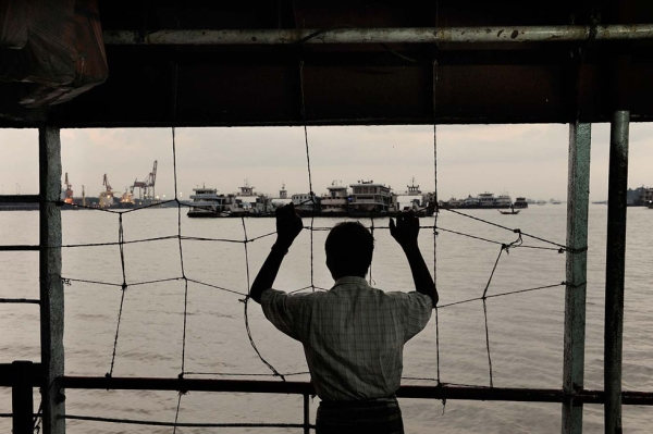 A man stares at Yangon harbor from a ferry. In spite of the reforms, Myanmar's economy is still in a dire situation. (Gilles Sabrié)
