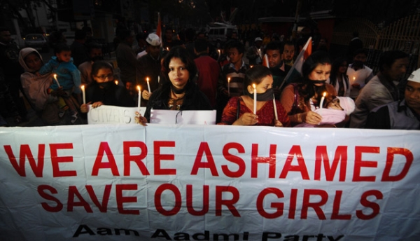 Indian protestors march behind a banner as they take part in a candlelight procession in Guwahati on December 29, 2012, after the death of a gang rape victim from the Indian capital New Delhi. (STRDEL/AFP/Getty Images)