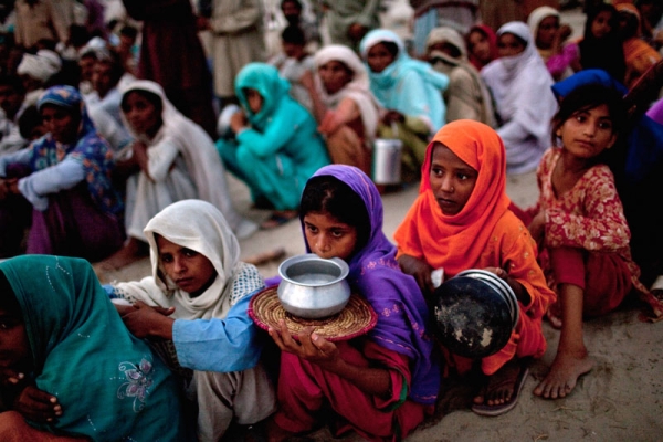 Villagers, displaced from their homes by flooding, hold empty containers as they queue for soup and relief rations on August 25, 2010 in the Sultan Colony Army flood relief camp near Muzaffargarh in Punjab, Pakistan. (Daniel Berehulak/Getty Images) 