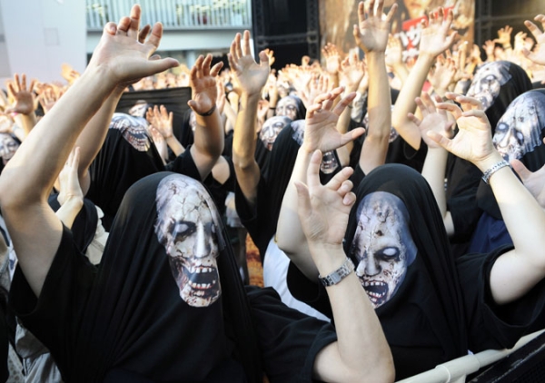 Movie fans wearing zombie printed T-shirts over their heads in Tokyo