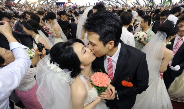 Couples kiss in a Taipei mass wedding
