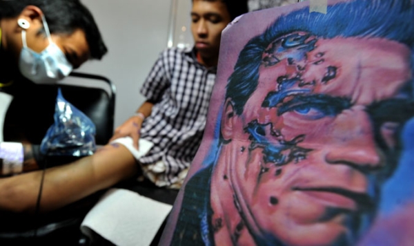 A Filipino tattoo artist works on a customer&#39;s design during the annual tattoo exposition, dubbed as Dutdutan X, at the World Trade Center in Manila on September 24, 2010.