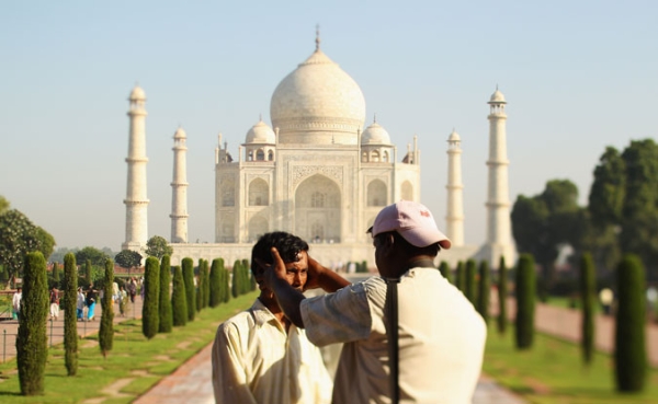 A photographer poses a tourist the Taj Mahal on September 29, 2010 in Agra, India.