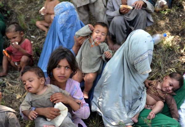 Women and children gather on higher ground after fleeing their homes in Nowshera&apos;s Mohib Bhanda area on July 31, 2010. (A. Majeed/AFP/Getty Images)