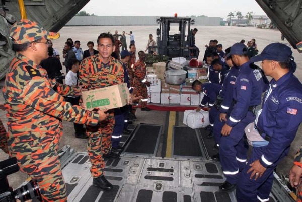 Members of the Special Malaysia Disaster Assitance and Rescue Team (SMART) load emergency and relief supplies into an aircraft for Japan at the Subang Airforce base in Kuala Lumpur on March 15, 2011. (AFP/Getty Images) 