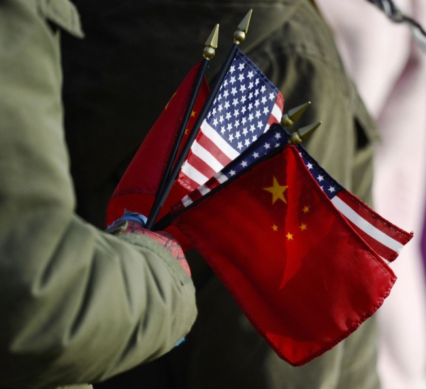An onlooker holds the US and China flags as US President Barack Obama welcomes Chinese President Hu Jintao during a State Arrival ceremony on the South Lawn of the White House in Washington, DC, January 19, 2011. (Jewel Samad/AFP/Getty Images)