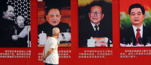 An elderly man looks at portraits of former Chinese communist leaders (L to R) Mao Zedong, Deng Xiaoping, Jiang Zemin and current president Hu Jintao in Ditan Park in Beijing on June 28, 2011. (Peter Parks/AFP/Getty Images)