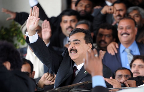 Pakistani Prime Minister Yousuf Raza Gilani (C) surrounded by security personnel and lawyers acknowledges the crowd as he leaves the Supreme Court after adjourning the contempt hearing in Islamabad on Jan. 19, 2012. (Aamir Qureshi/AFP/Getty Images) 