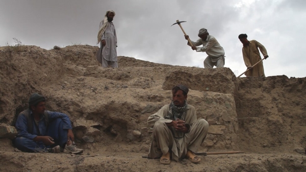 Locals from relocated villages in the Mes Aynak area in Logar province working for low wages to remove dirt and rocks from the site exposing buried artifacts. (Brent Huffman)